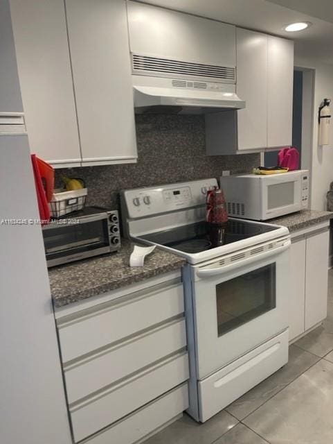 2401 S Ocean Dr Unit 1203, Hollywood, FL 33019 - kitchen featuring light tile patterned floors, white cabinets, white appliances, and decorative backsplash