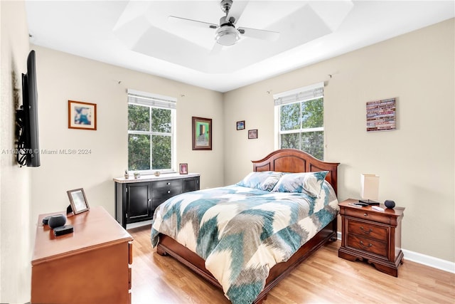 bedroom with multiple windows, ceiling fan, and light hardwood / wood-style floors