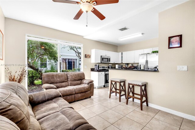 living room with ceiling fan and light tile patterned flooring