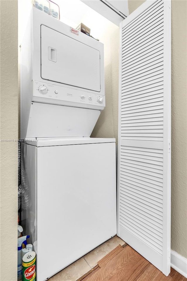 laundry area featuring light hardwood / wood-style floors and stacked washer and clothes dryer