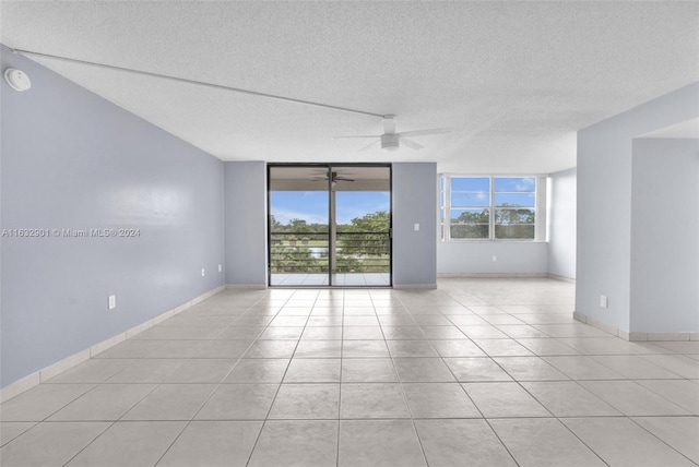 tiled spare room with ceiling fan and a textured ceiling