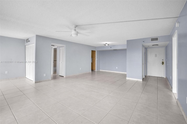 unfurnished room featuring light tile patterned floors, a textured ceiling, and ceiling fan