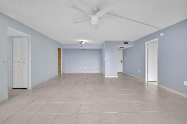 spare room featuring light tile patterned floors, a textured ceiling, and ceiling fan