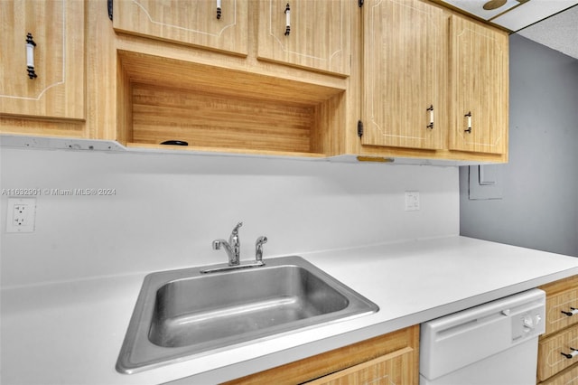 kitchen featuring light brown cabinetry, dishwasher, and sink