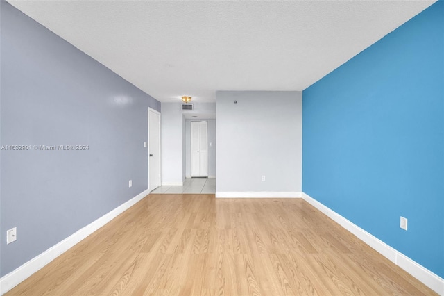 empty room featuring light hardwood / wood-style floors and a textured ceiling