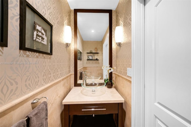 bathroom featuring vanity and wallpapered walls