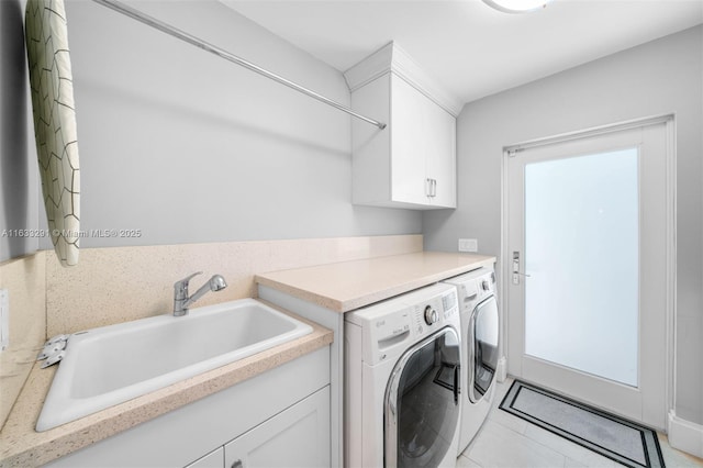 laundry area featuring cabinet space, washing machine and dryer, light tile patterned floors, and a sink