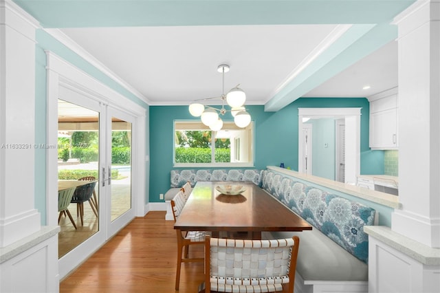 dining area featuring baseboards, a chandelier, breakfast area, wood finished floors, and crown molding