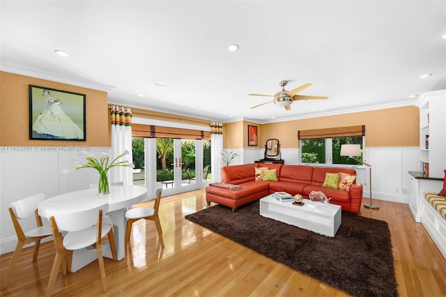 living room featuring ceiling fan, a healthy amount of sunlight, crown molding, and light hardwood / wood-style flooring