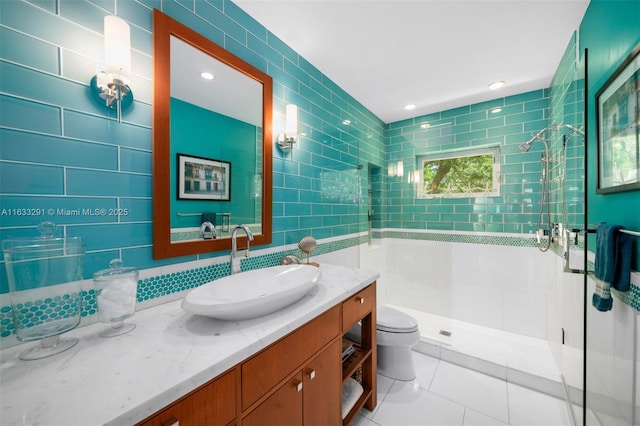 bathroom with toilet, tile walls, recessed lighting, a shower stall, and vanity