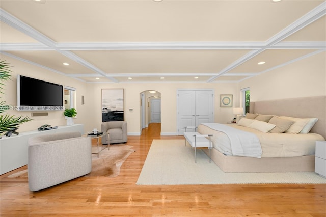 bedroom with light wood finished floors, arched walkways, recessed lighting, and coffered ceiling
