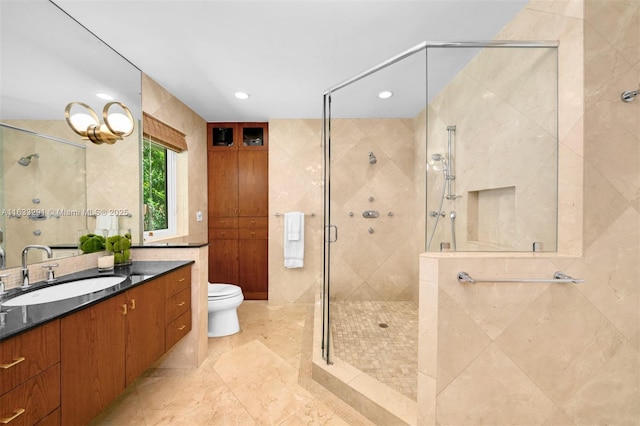 bathroom featuring an enclosed shower, vanity, toilet, and tile walls