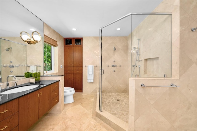 bathroom featuring recessed lighting, toilet, vanity, tile walls, and a stall shower