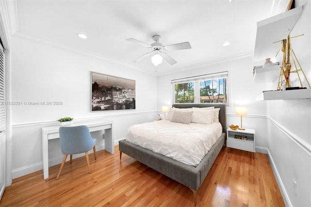 bedroom featuring ceiling fan, ornamental molding, and light hardwood / wood-style flooring