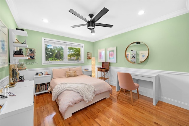 bedroom featuring recessed lighting, ornamental molding, a wainscoted wall, and light wood-style flooring
