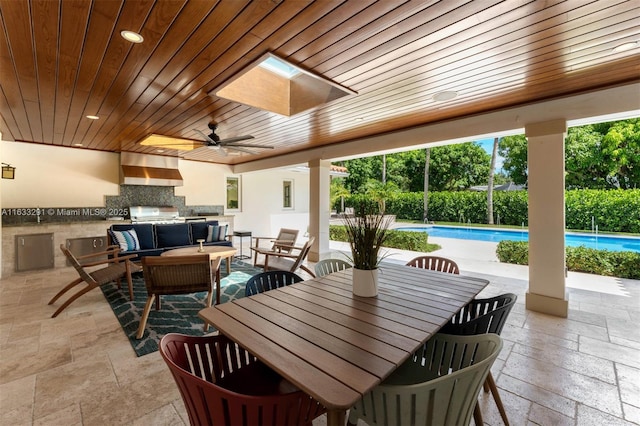 view of patio / terrace featuring a ceiling fan, exterior kitchen, an outdoor pool, an outdoor hangout area, and outdoor dining area