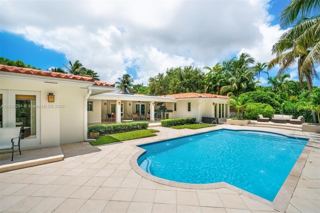 pool featuring outdoor lounge area, a patio area, and french doors