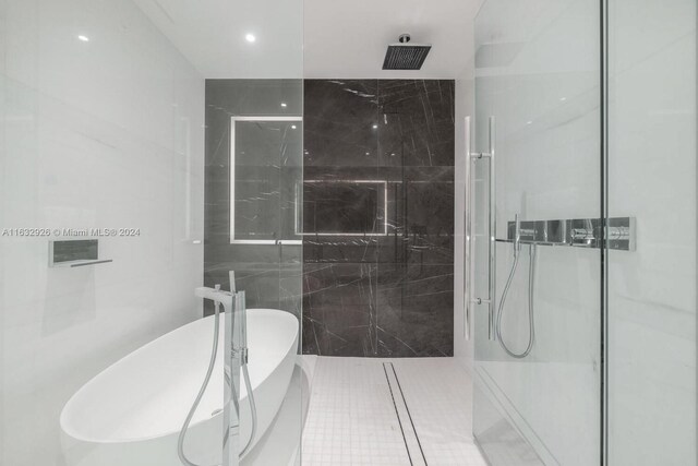 bathroom featuring tile patterned floors, plus walk in shower, and tile walls