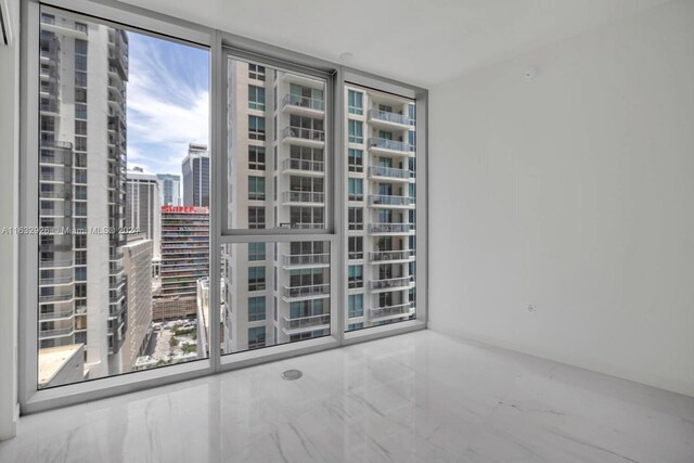 unfurnished room with a wall of windows