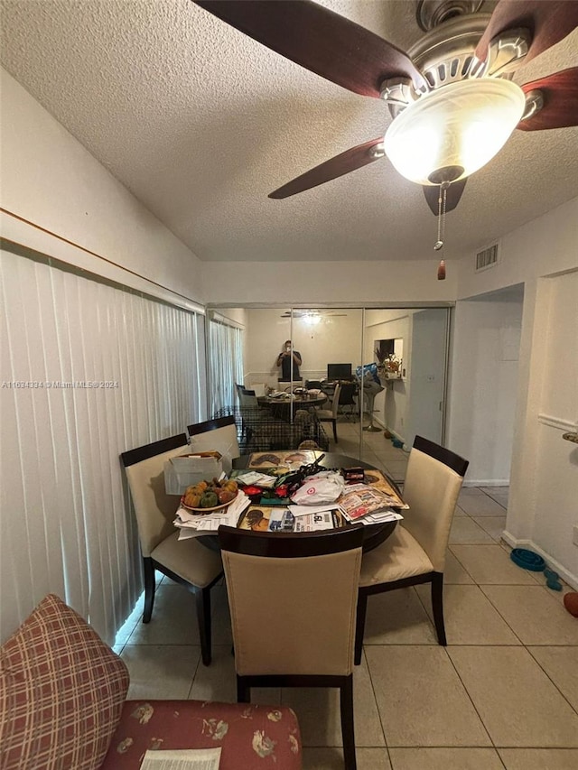 dining room with a textured ceiling, ceiling fan, and light tile patterned floors