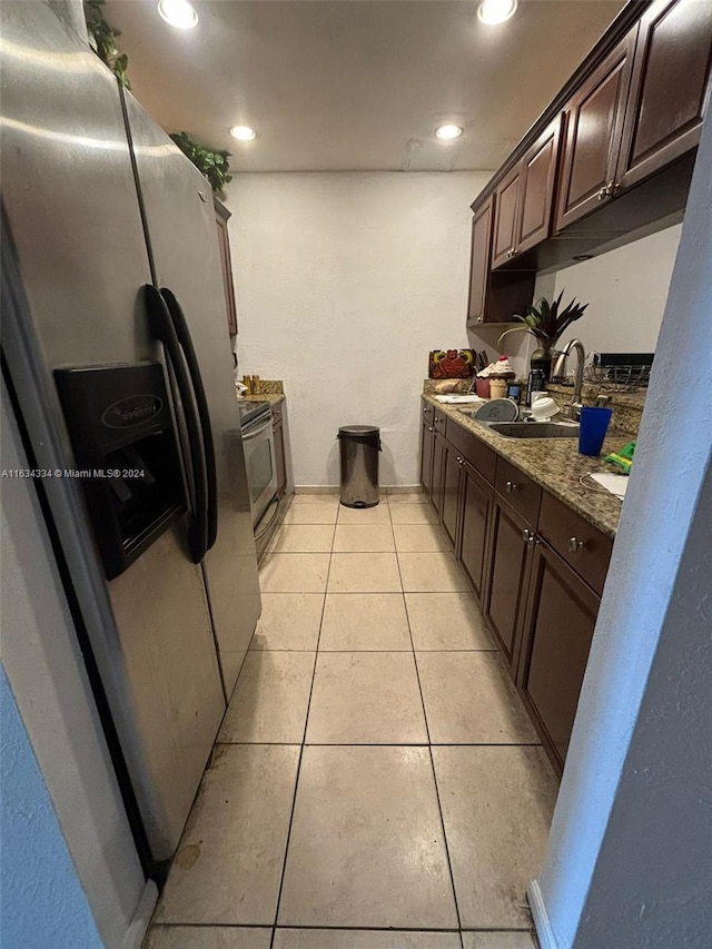 kitchen featuring sink, light tile patterned flooring, light stone countertops, and stainless steel appliances