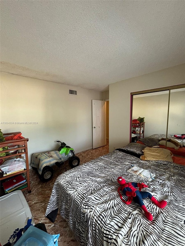 carpeted bedroom featuring a closet and a textured ceiling