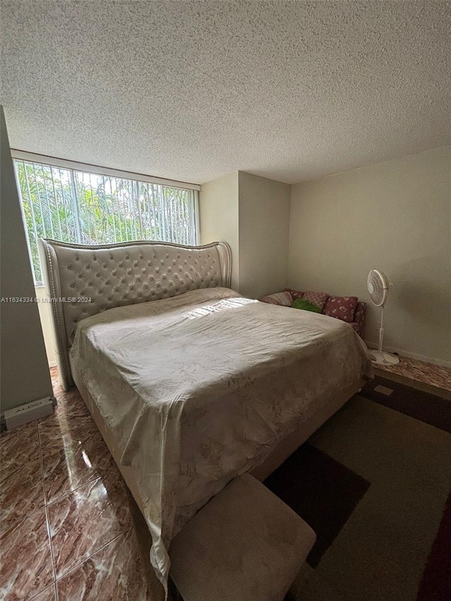 bedroom with dark tile patterned flooring and a textured ceiling