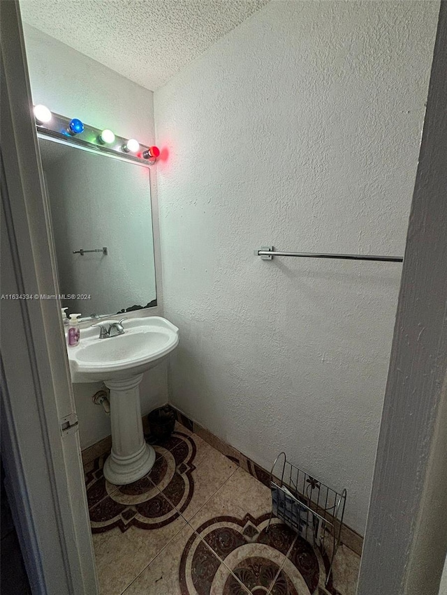 bathroom with tile patterned flooring and a textured ceiling