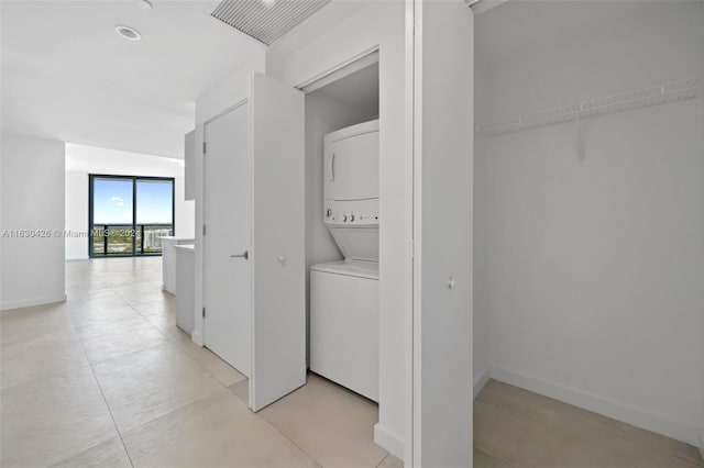 interior space with stacked washing maching and dryer and light tile patterned flooring