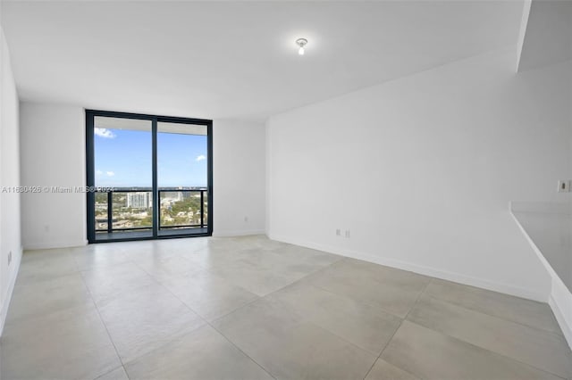 tiled spare room with floor to ceiling windows