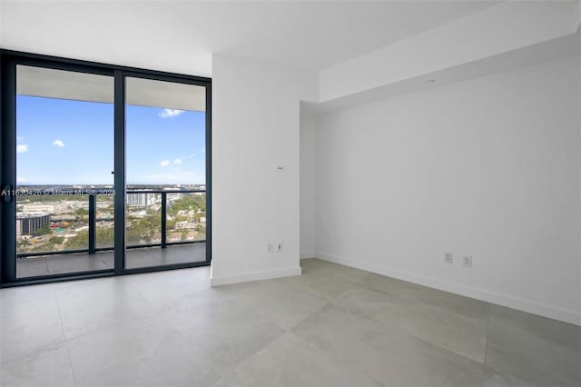 tiled empty room featuring floor to ceiling windows