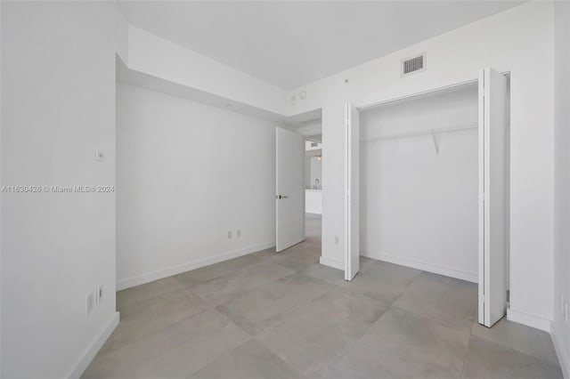 unfurnished bedroom with a closet and light tile patterned floors