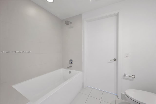 bathroom featuring tile patterned floors, tiled shower / bath combo, and toilet