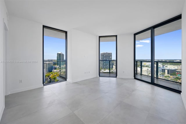 empty room with light tile patterned flooring and floor to ceiling windows