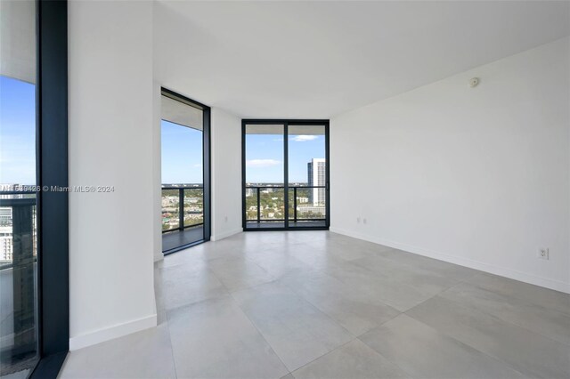 unfurnished room with light tile patterned floors and expansive windows