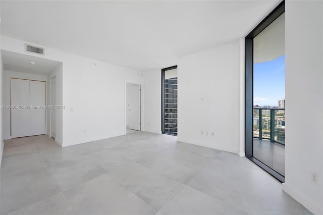 tiled spare room with expansive windows