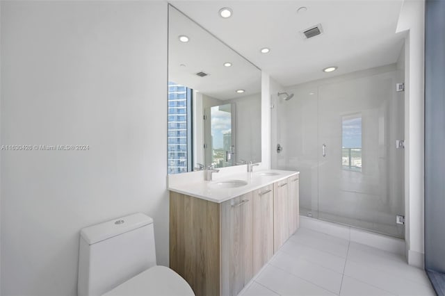 bathroom with walk in shower, tile patterned flooring, double sink vanity, toilet, and plenty of natural light