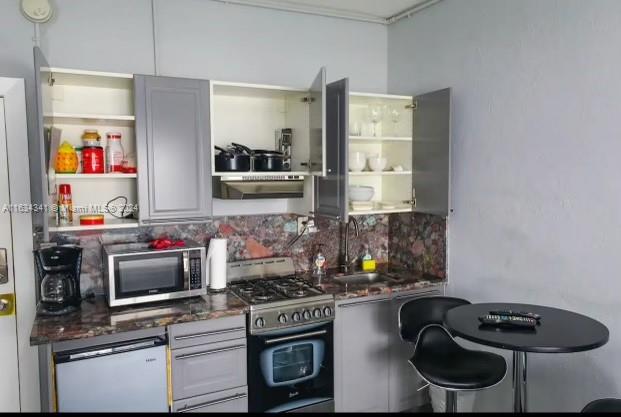 kitchen featuring ventilation hood, sink, dishwasher, double oven range, and backsplash