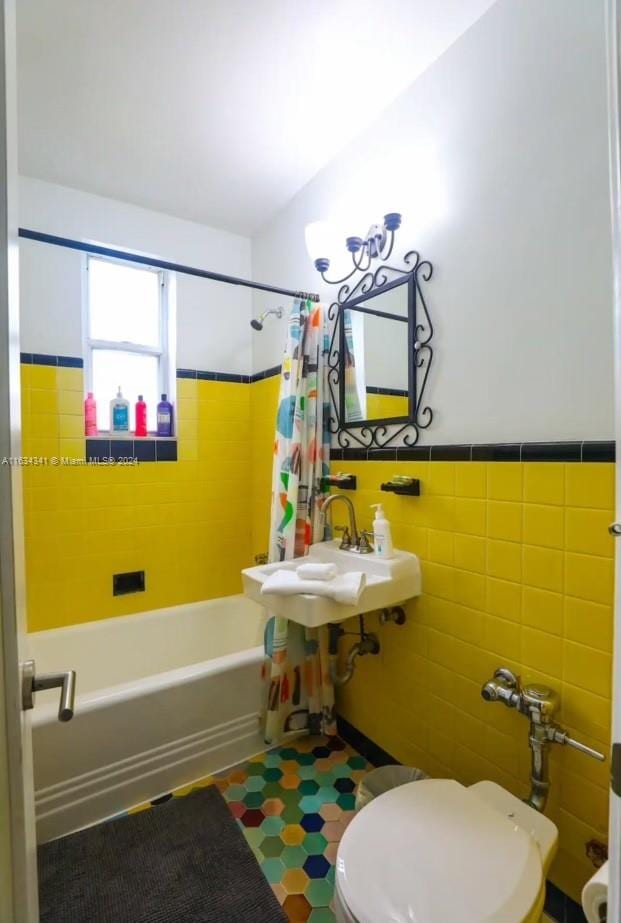 full bathroom featuring sink, shower / bath combo with shower curtain, tile walls, tile patterned floors, and toilet