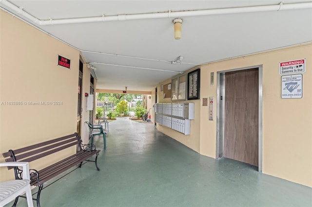 corridor featuring concrete floors and elevator