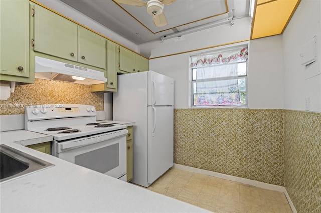 kitchen with under cabinet range hood, white appliances, green cabinets, light countertops, and wainscoting