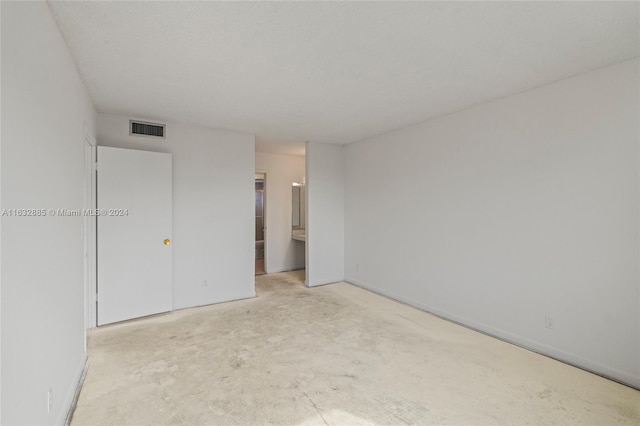 unfurnished bedroom featuring visible vents and ensuite bathroom