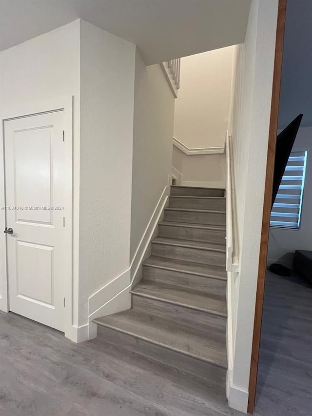 stairs with wood finished floors and baseboards