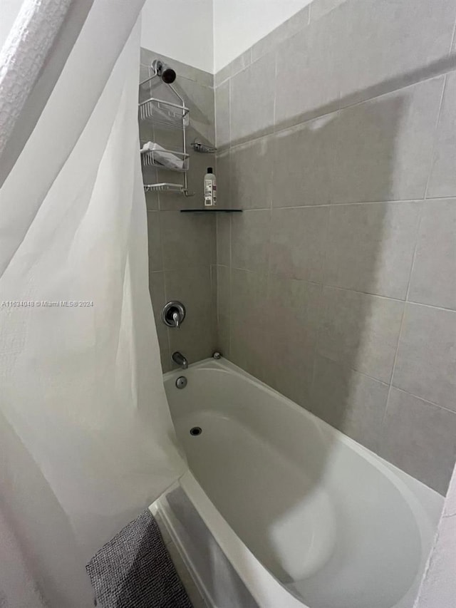 bathroom with shower / bath combo with shower curtain