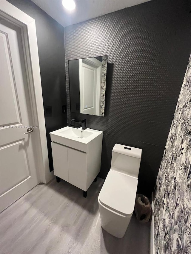 bathroom with vanity, hardwood / wood-style floors, and toilet