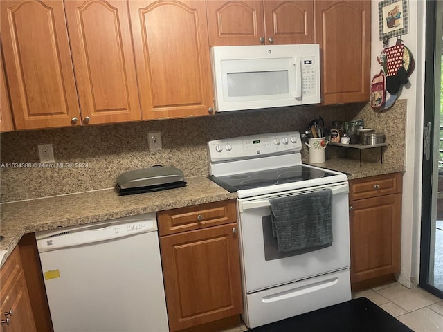 kitchen with light tile patterned flooring, backsplash, and white appliances