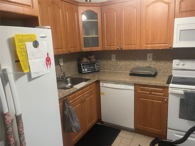 kitchen with tasteful backsplash, sink, white appliances, and light tile patterned floors