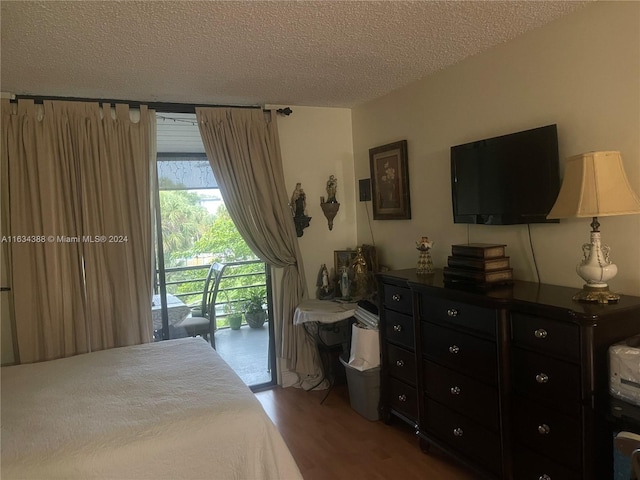 bedroom featuring a textured ceiling, wood-type flooring, and access to outside