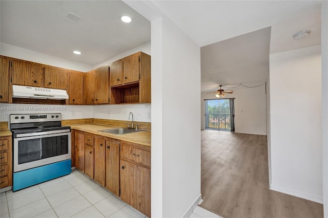 kitchen featuring light hardwood / wood-style floors, sink, stainless steel electric stove, and ceiling fan