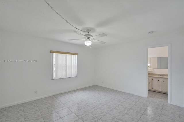 tiled empty room featuring ceiling fan